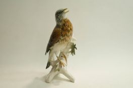 A 20th Century ceramic model of a Wren perched on a tree stump, 25cm high.