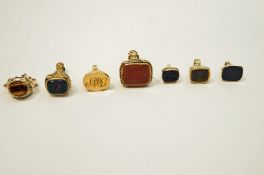 A small gold and plain black onyx seal,