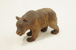 A 20th century carved black forest bear, with glass bead eyes, 23cm long,