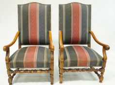 A pair of elbow chairs with upholstered backs and seats with walnut arms and legs.