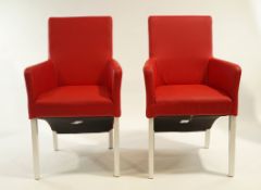 A pair of modern red leather arm chairs