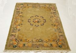 A Chinese silk rug, with central medallion of flowers on a pale green field.