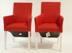 A pair of modern red leather arm chairs