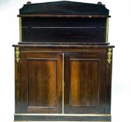An early 19th Century rosewood chiffonier with raised back above two panelled doors on plinth base.