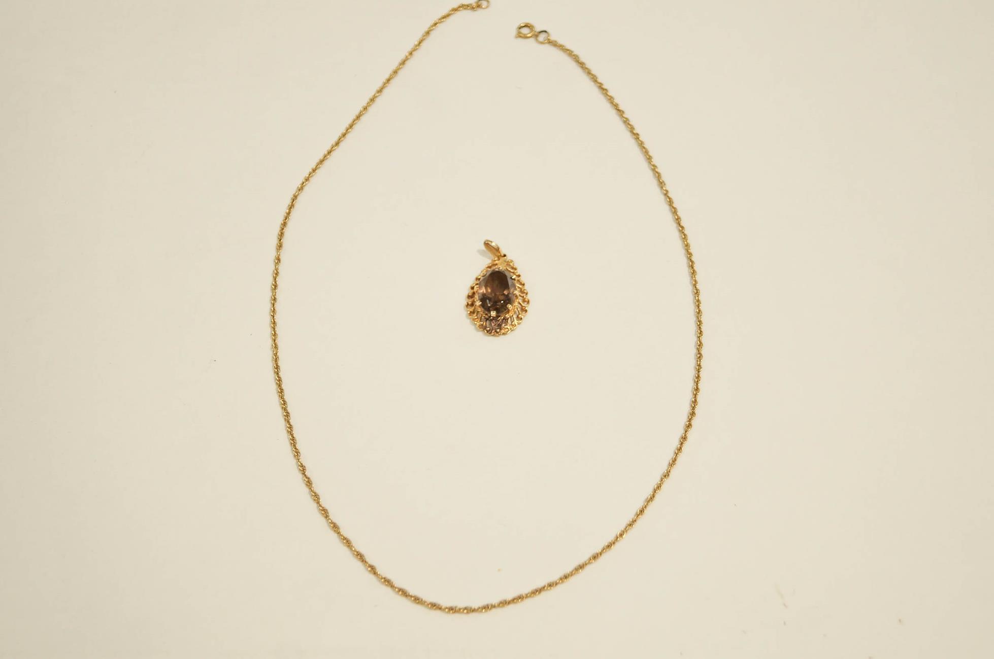 A smoky quartz pendant on a 9 carat gold mount, on a chain, 6.