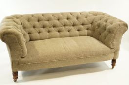 A Victorian chesterfield sofa, recently button upholstered, with turned plank legs.