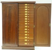 A Victorian mahogany collector's cabinet with two arched panelled doors enclosing thirty two