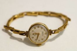 Buren Grand Prix, a lady's 9ct gold round wrist watch on a 9 ct gold expanding baton link bracelet,