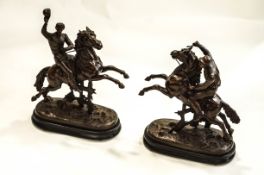 Two cold cast metal figures of Jockeys on horseback, both mounted on oval ebonised bases,