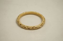 Ivory bangle, circa 1935, carved with an Asian dragon, internal diameter 6.