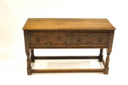 An oak Jacobean revival sideboard with two drawers and open stand, Phillips of Bristol label,