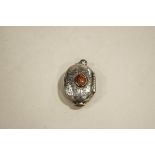 A pill box locket, set with agates, the interior gilded, with indistinct marks, 5.