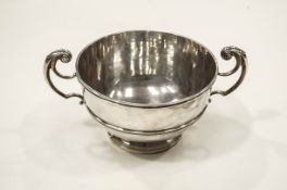 A silver punch bowl with two leaf-capped double scroll handles and a moulded border and band,