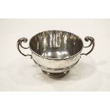 A silver punch bowl with two leaf-capped double scroll handles and a moulded border and band,