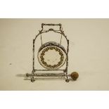 A silver plated dinner gong, to a leaf wrapped stand with a rustic hammer,