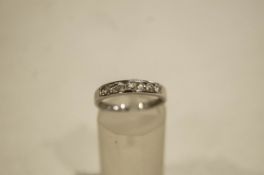 A 9 carat white gold ring, channel set with colourless stones, finger size K1/2, 1.