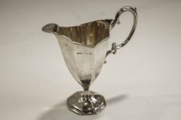 A Victorian silver helmet shaped cream jug with fluted sides, a double scroll handle,