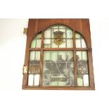 A stained and leaded glass panel, set within a door, depicting a nobleman upon horseback,