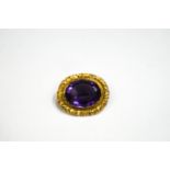 A Victorian oval amethyst brooch with a leaf carved border, 10.