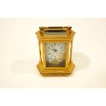 A 20th Century French brass and porcelain Carriage Clock, inset with six panels,
