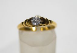 A diamond solitaire ring, the tiny eight-cut stone set in a while illusion mount on a yellow shank,