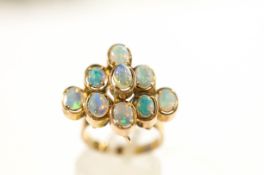 A nine stone opal ring, stamped '375', the oval shallow cabochons in a stepped arrangement,