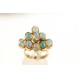 A nine stone opal ring, stamped '375', the oval shallow cabochons in a stepped arrangement,