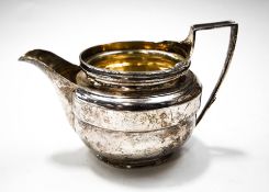 A George III silver oval milk jug with a moulded rim and an angular handle,