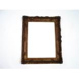 An ornate giltwood picture frame, with applied moulding of scrolls and flowers,