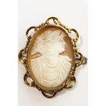 A late Victorian shell cameo brooch, the female profile in a C scroll edge mount stamped '9c', 5.