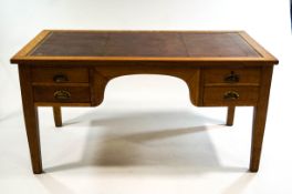 An early 20th century oak writing desk, with tooled leather writing surface,