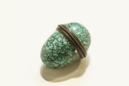 An enamelled thimble holder in the form of an egg,