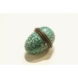 An enamelled thimble holder in the form of an egg,