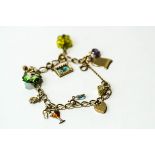 A 9 carat gold bracelet, of curb links, with charms attached, 18.