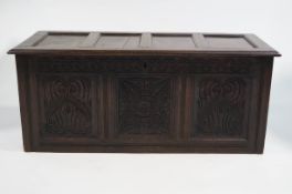 An 18th century oak panel coffer, with later heavily carved decoration,