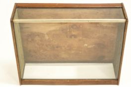 A table top mahogany display case, with open back and sloping glass top,