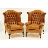 A pair of 20th Century tan leather button back armchairs, each with cabriole legs.