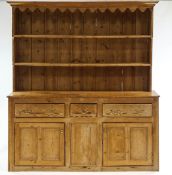 A Victorian pine kitchen dresser, with rack over a three drawer cupboard base,