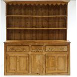 A Victorian pine kitchen dresser, with rack over a three drawer cupboard base,