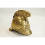 A brass helmet, decorated on the front with a pair of axes either side of a laurel wreath,