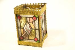 A decorative coloured and clear glass hall lantern, within a gilt metal frame,