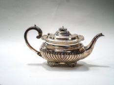 A silver oblong teapot, part fluted with a leaf chased and gadrooned border,