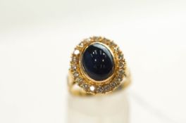 A sapphire and diamond ring, stamped '18ct', the oval cabochon measuring approximately 11 mm by 8.