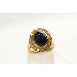A sapphire and diamond ring, stamped '18ct', the oval cabochon measuring approximately 11 mm by 8.