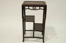 A Chinese rosewood table with pierced frieze and asymmetrical shelves,