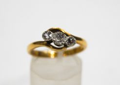 A diamond three stone cross-over ring, the old-cuts approximately 0.