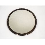 An oval brass framed mirror with scroll detail and bevelled glass,