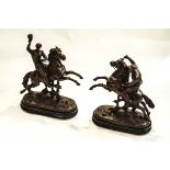 Two cold cast metal figures of Jockeys on horseback, both mounted on oval ebonised bases,