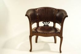 A 20th century tub chair with studded leatherette upholstery