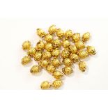 A collection of Indian filled gold beads, from a necklace,